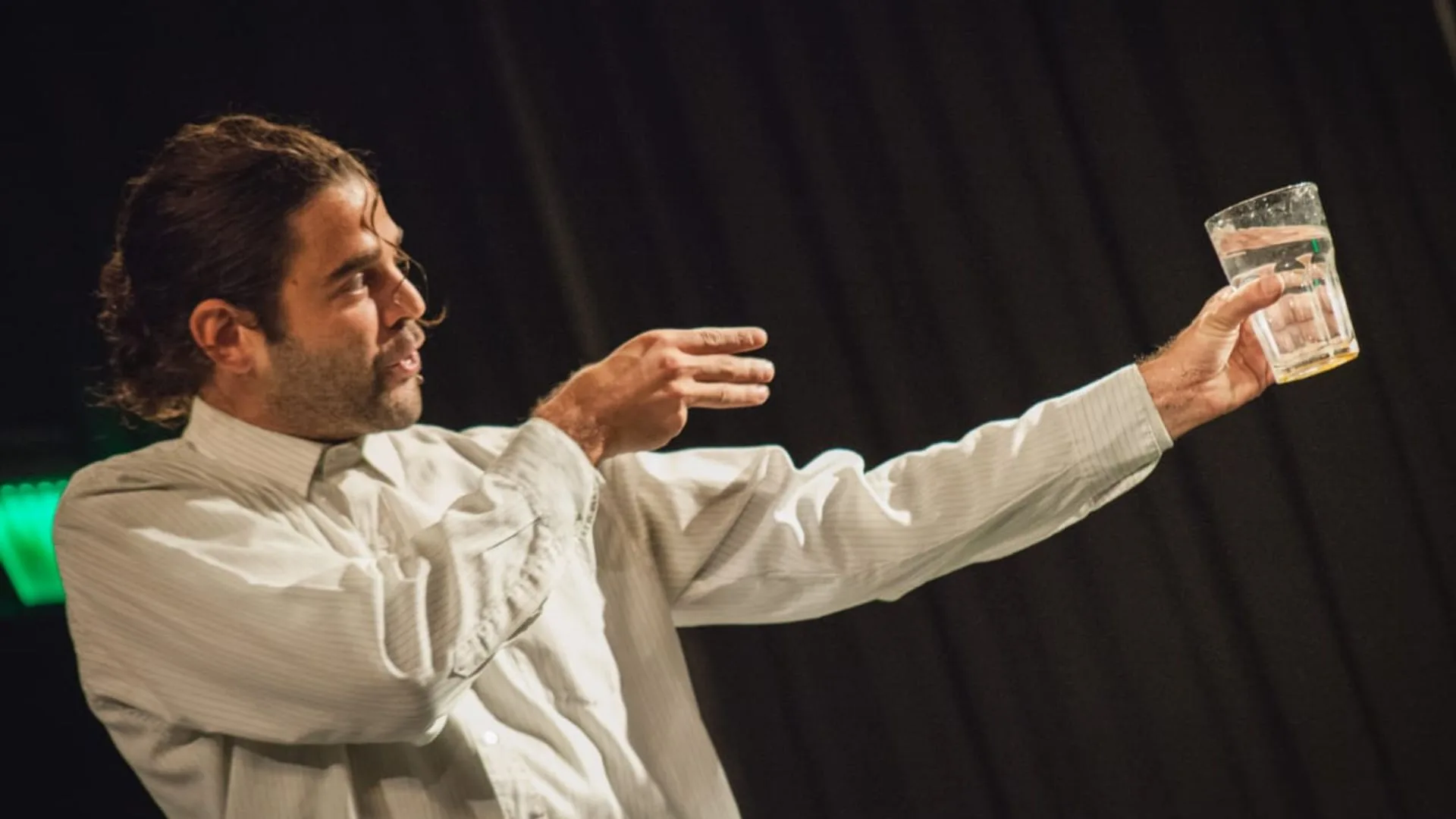 El actor Santiago San Paulo sosteniendo un vaso de agua en una escena de la obra Los Ahogados