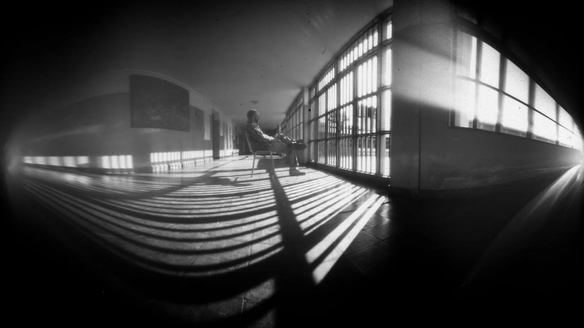 Foto Estenopeica de una persona sentada en una silla frente a un gran ventanal